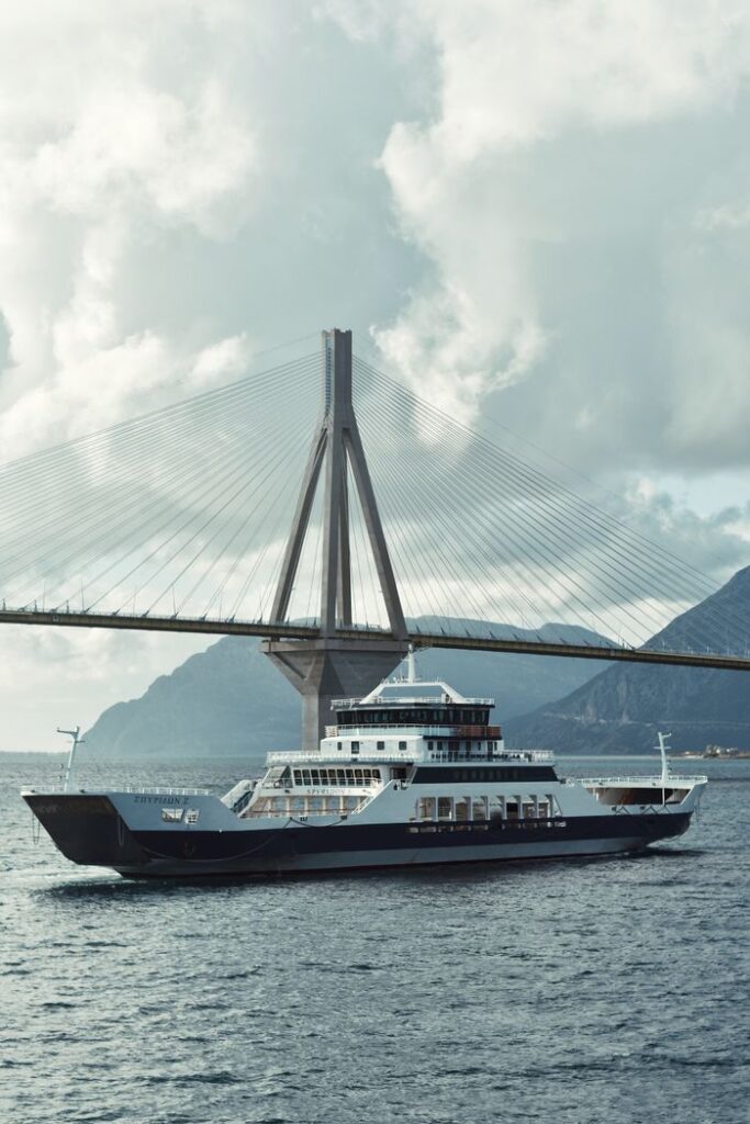 Ferry sailing under the iconic Rio-Antirrio Bridge in Greece.